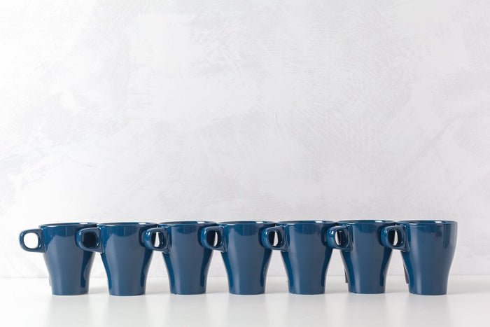  Row of blue coffee mugs on a white table