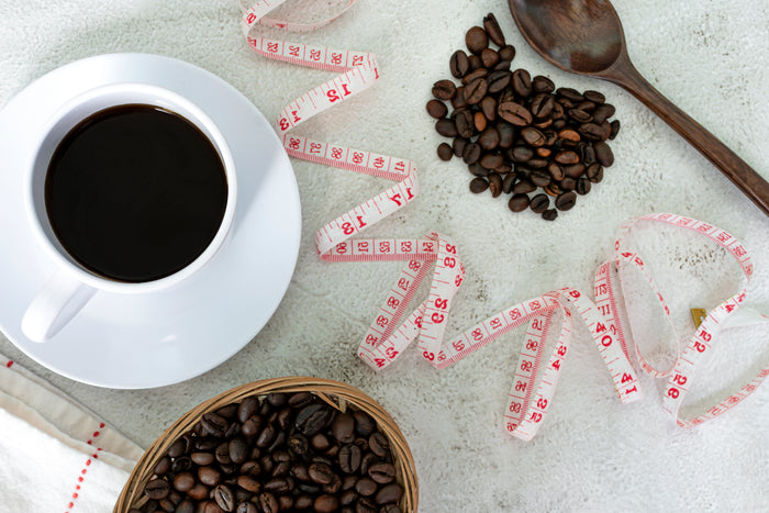 cup coffee-coffee beans-white background-with-measure tape