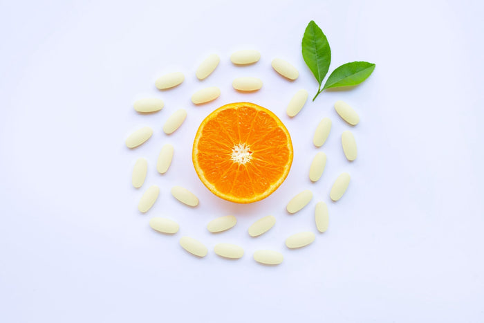  Orange slice with vitamin tablets arranged on white background