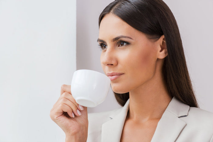 a beautiful business woman drinking a cup of coffee