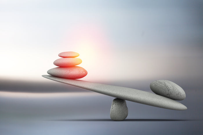 A serene image of stones balanced on a seesaw, symbolising emotional balance and harmony.